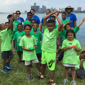 A group photo of kids on Belle Isle next to the Detroit River
